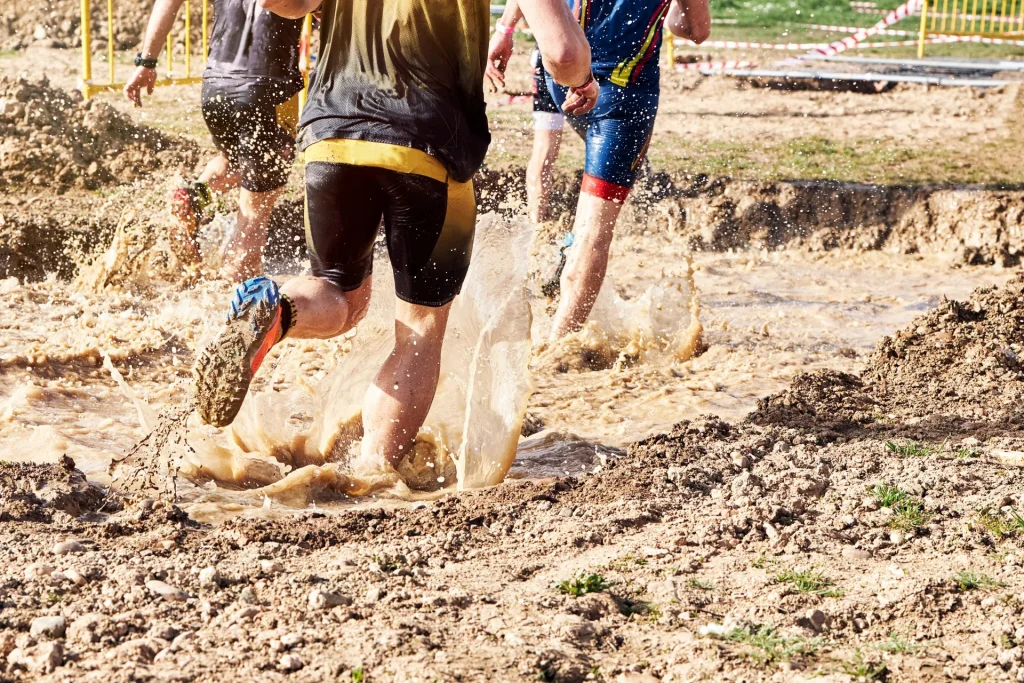 Group-of-participants-in-an-obstacle-course-race-running-across-a-pool-of-water.-Spartan-race
