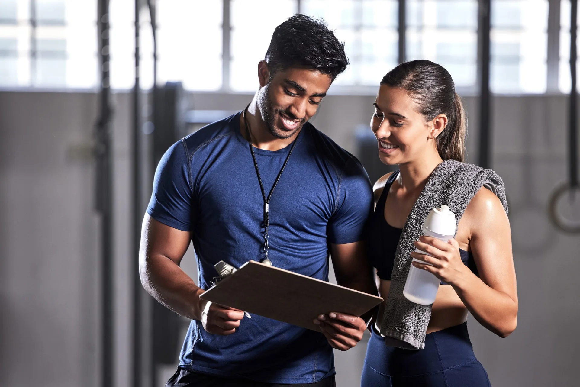 Fitness coach discussing training, workout plan and progress in a health and wellness facility