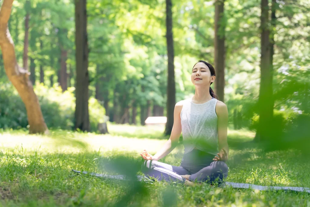asian-woman-meditating-woods-forest-yoga