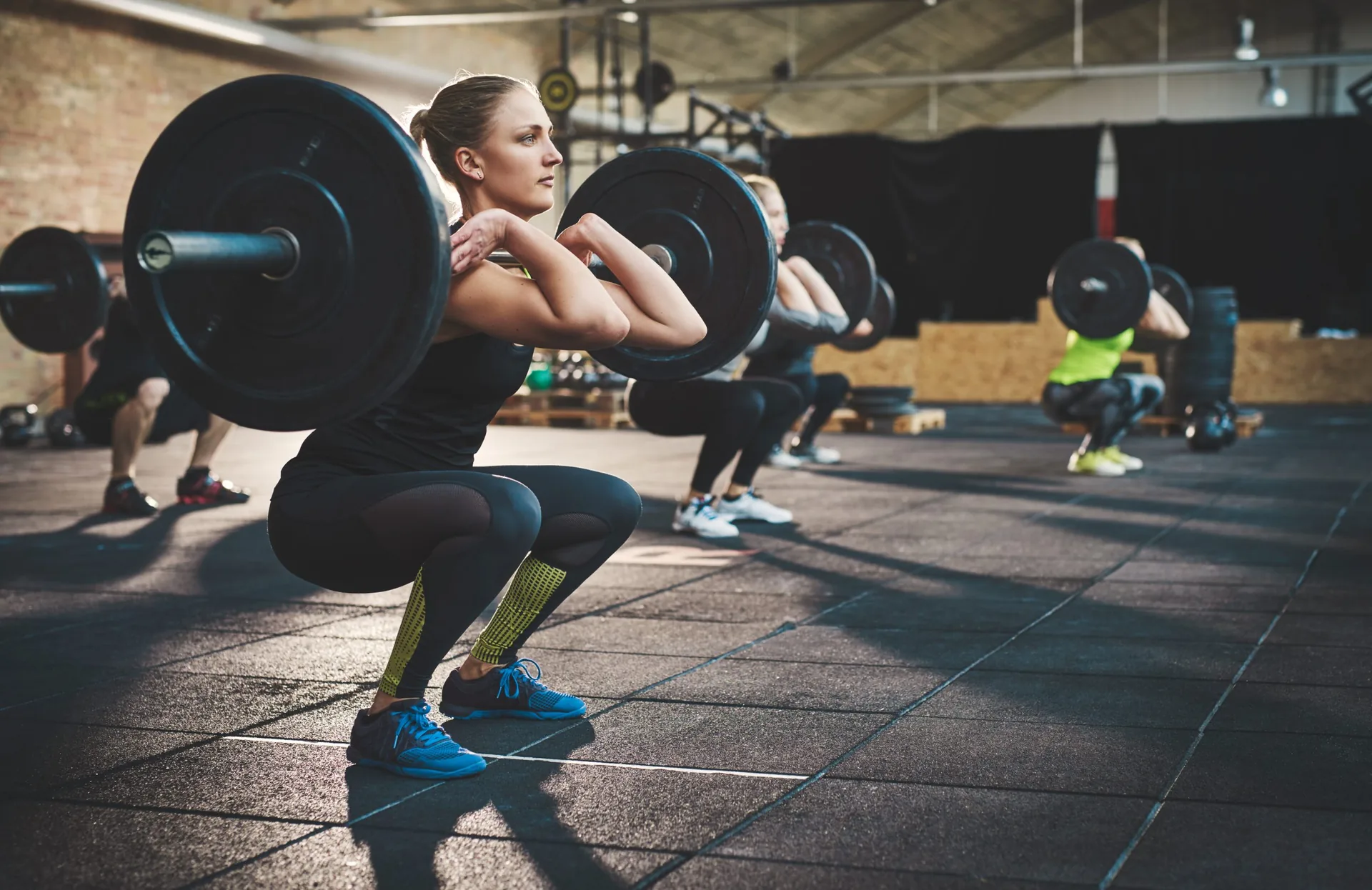 fit-young-woman-lifting-barbells-looking