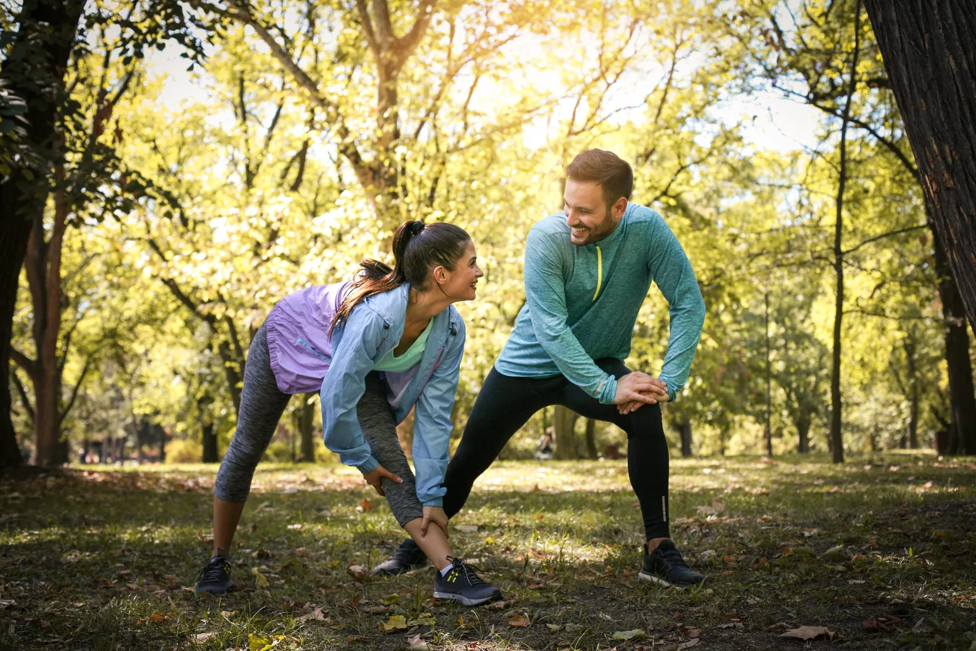 couple-stretching-park-young-working-exercise