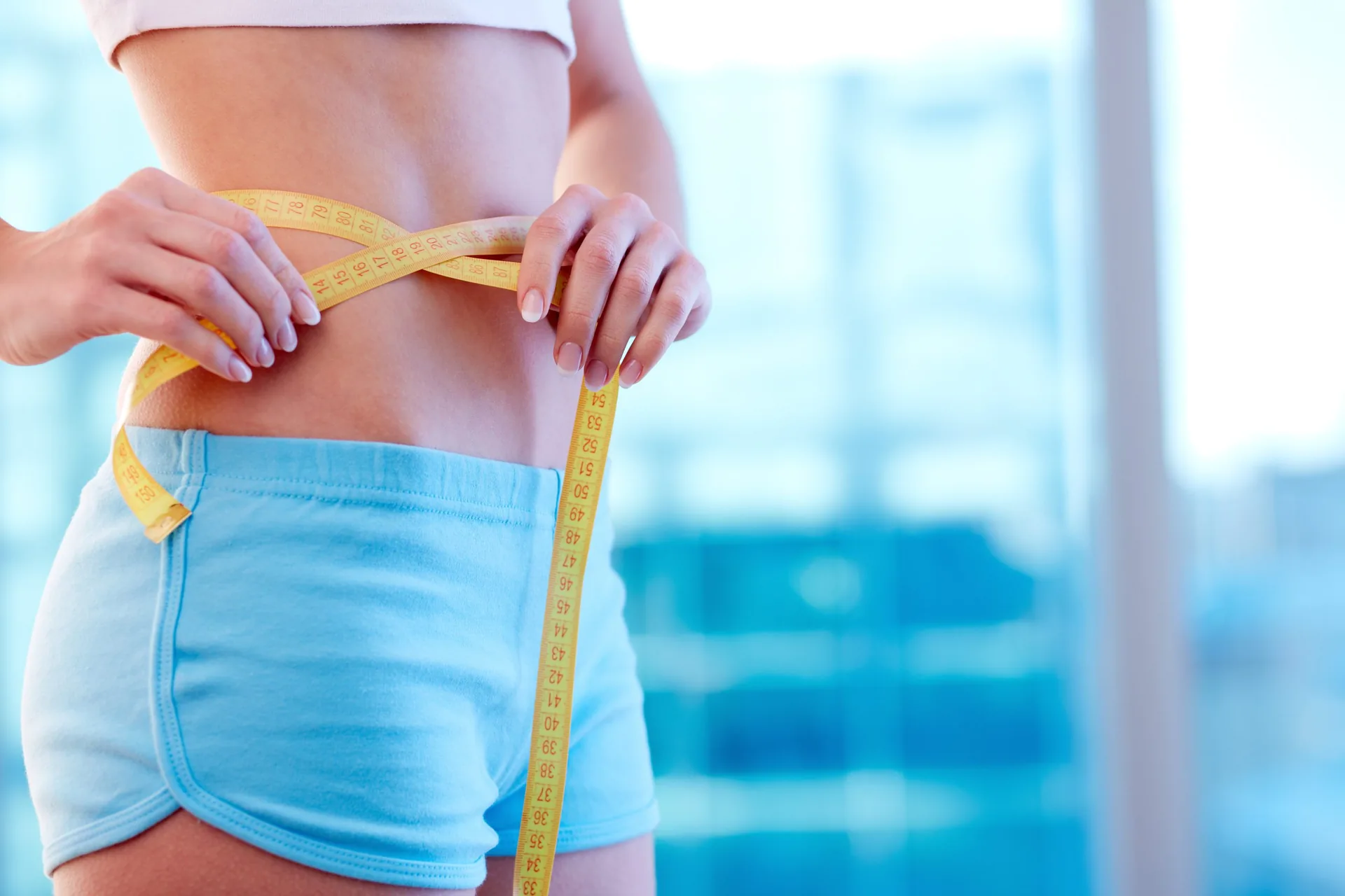 close-woman-sportswear-measuring-her-waist