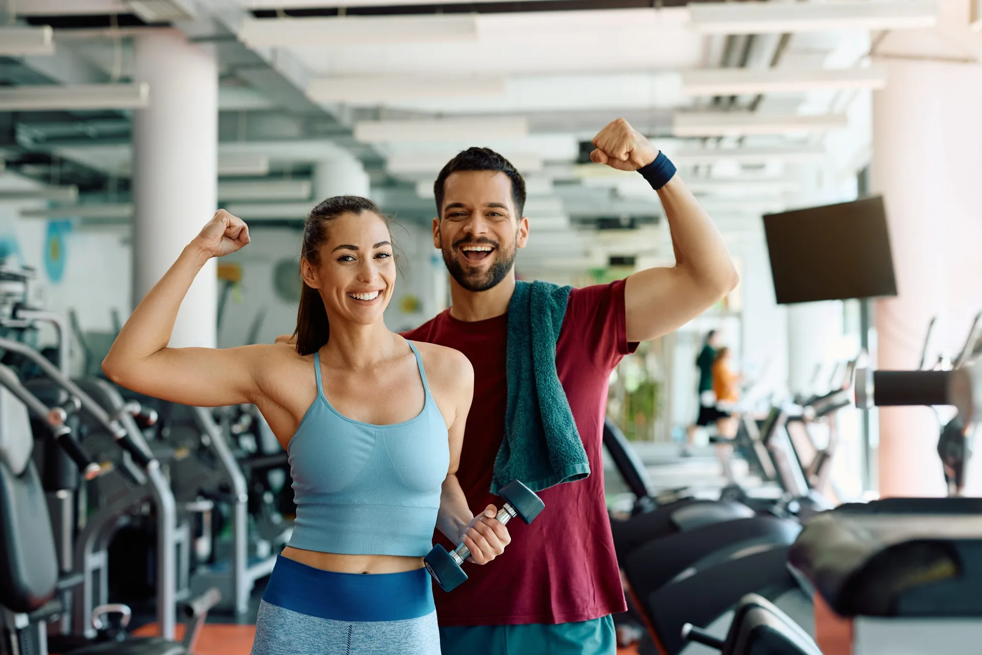happy-athletic-couple-flexing-their-muscles