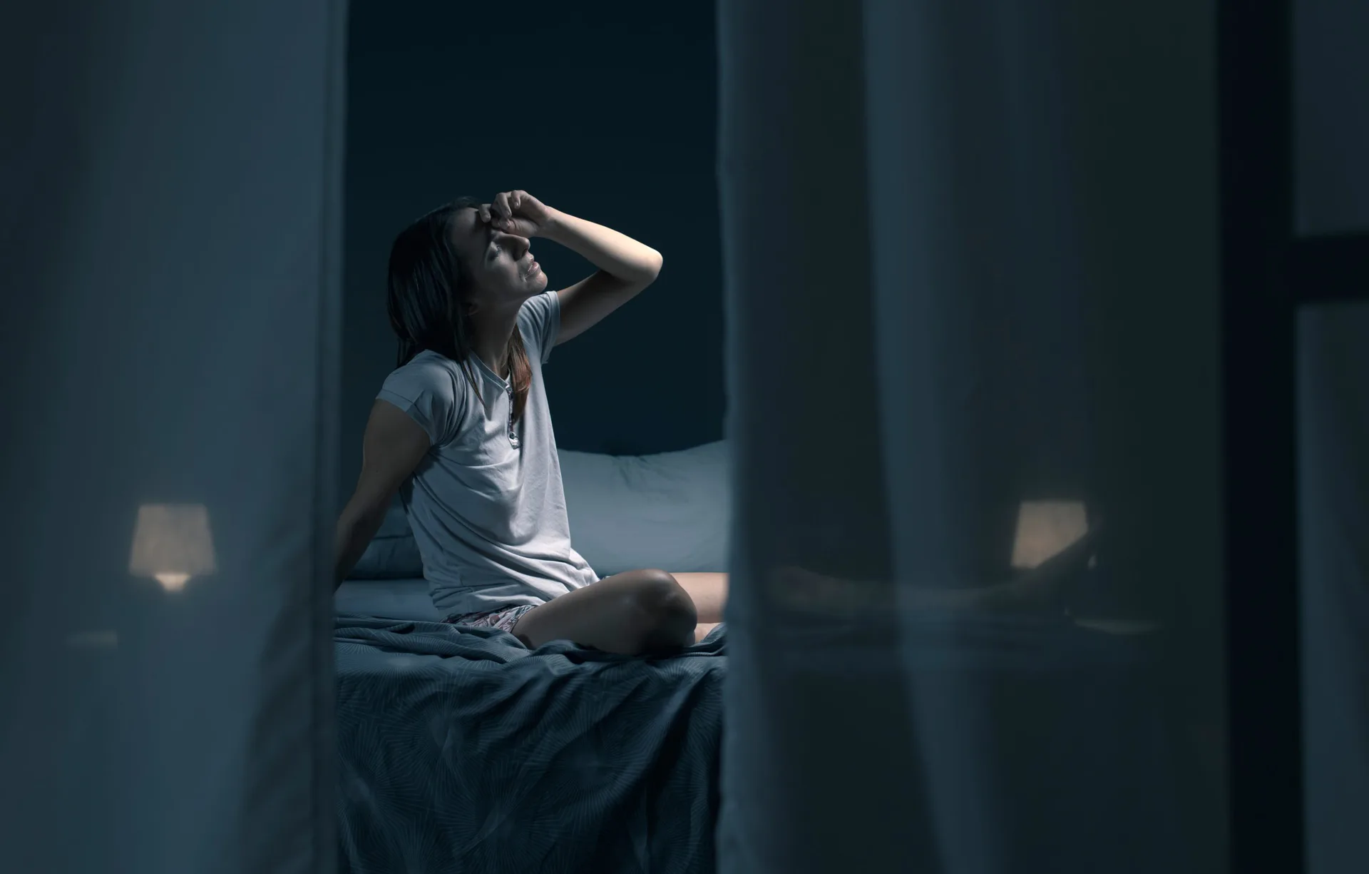 Tired,Woman,Sitting,In,Bed,At,Night,With,Open,Window,