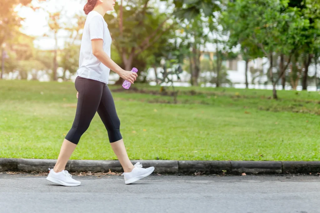 woman-walking-park-bottle-water-summer