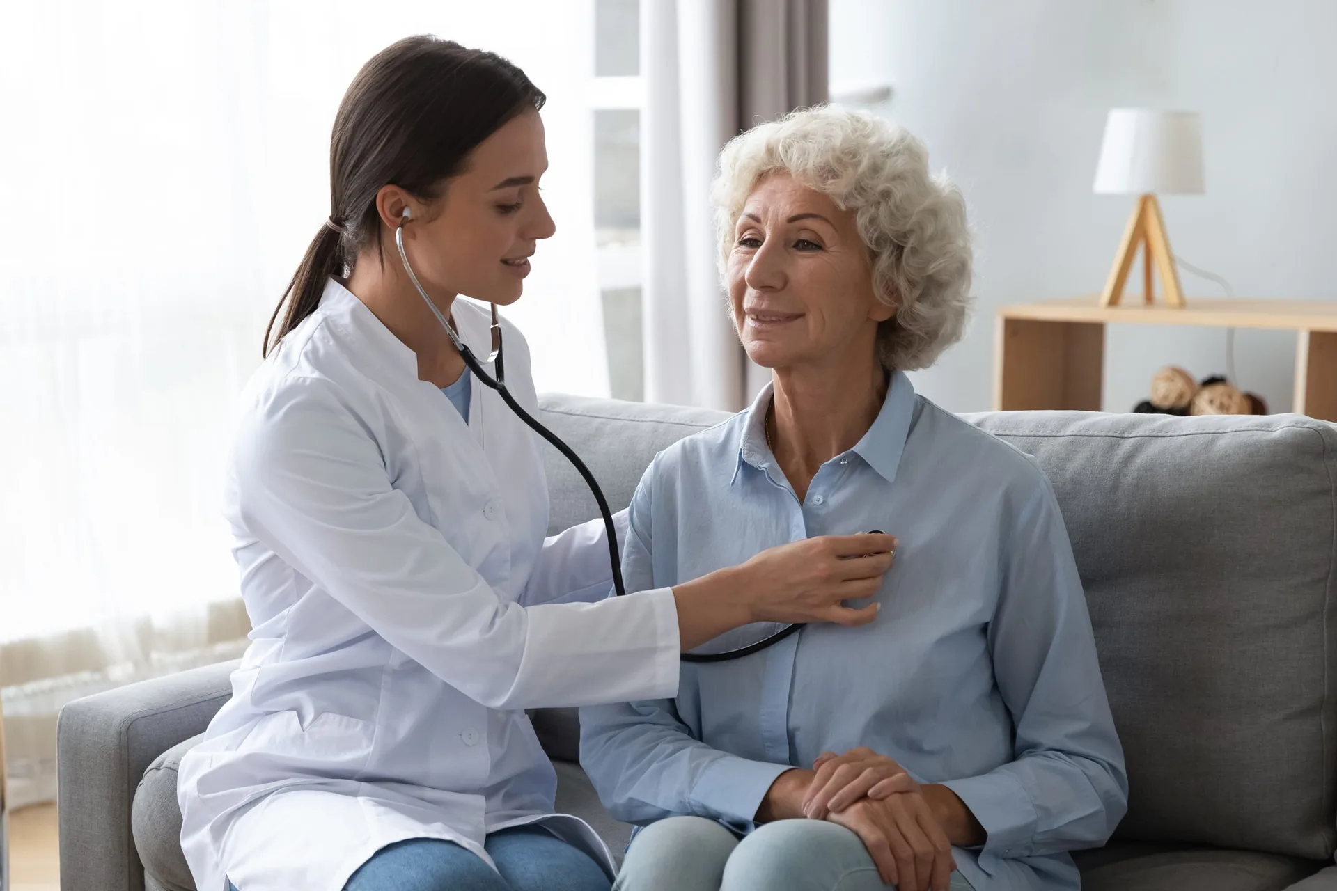 Young,,Nurse,Doctor,Gp,Holding,Stethoscope,Examining,Old,Senior