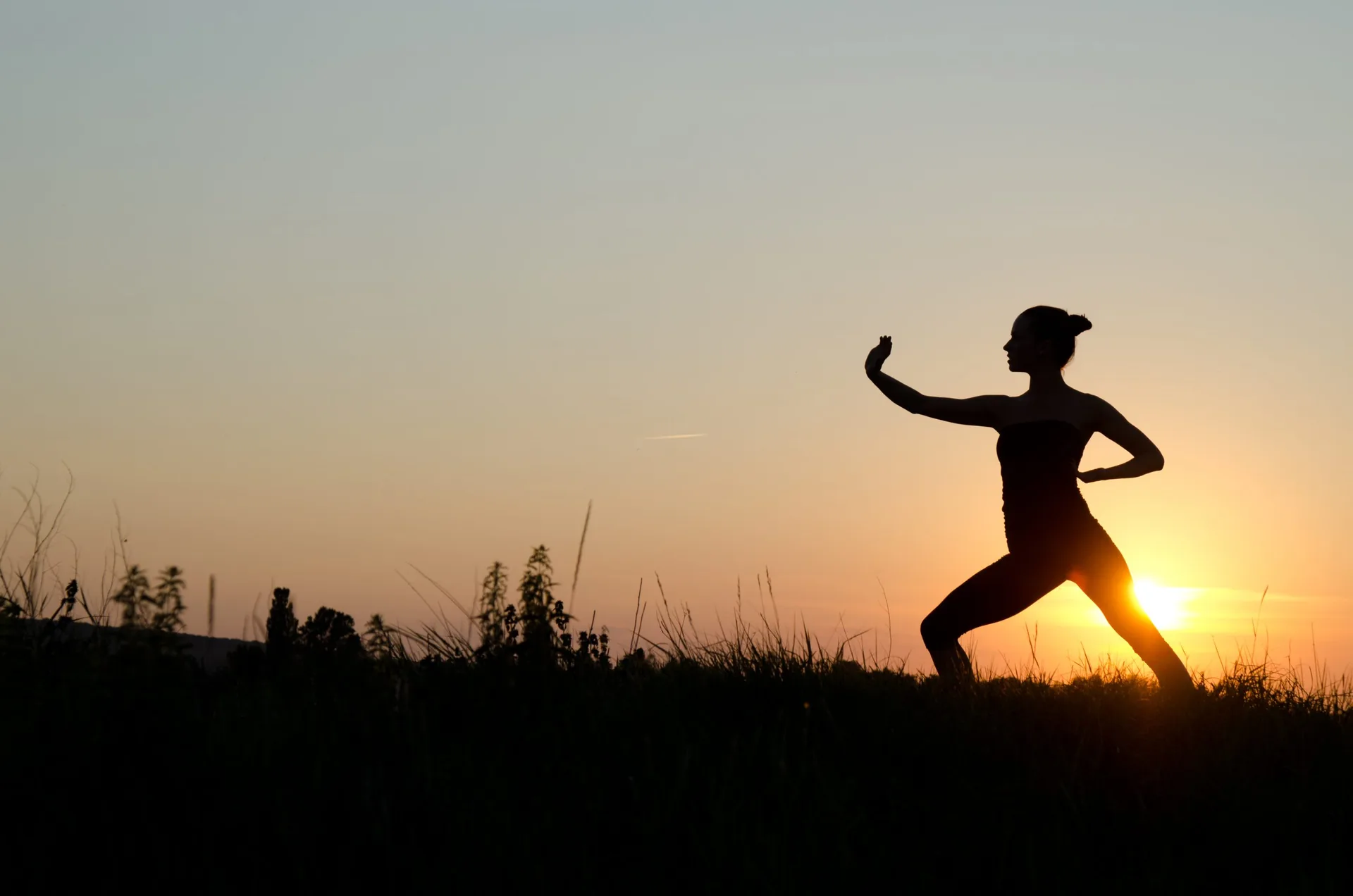 woman-praticing-tai-chi-chuan-sunset-