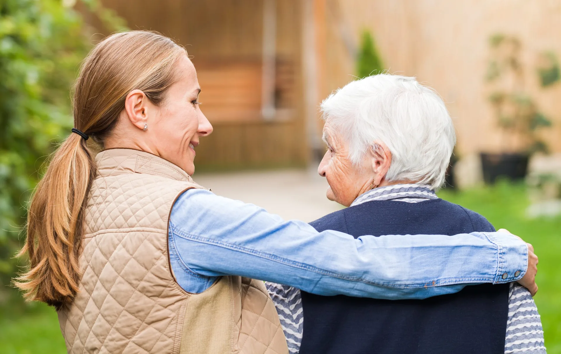 young-carer-walking-elderly-woman-park-