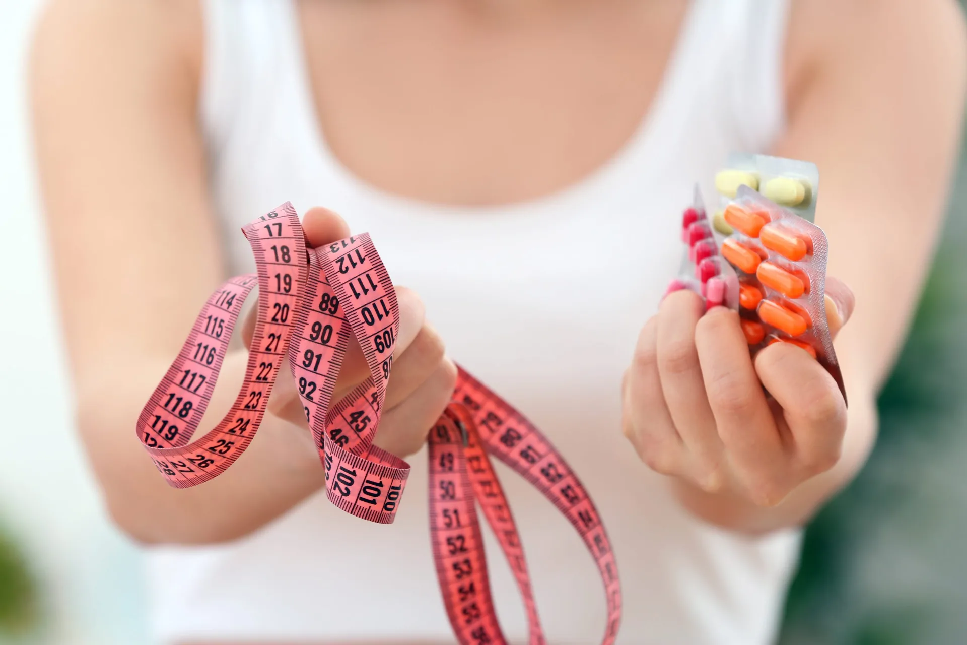 young-woman-holding-packs-pills-measuring