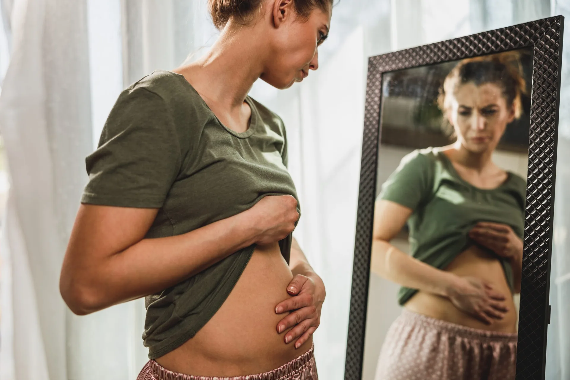 frown-young-woman-standing-front-mirror
