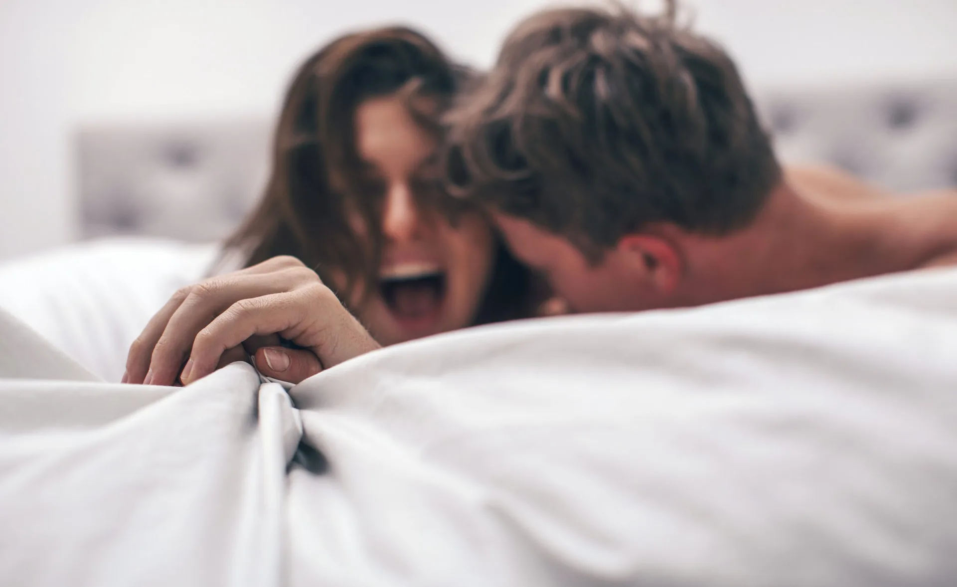 Beautiful,Brunette,Girl,And,Guy,Lying,In,Bed,And,Holding